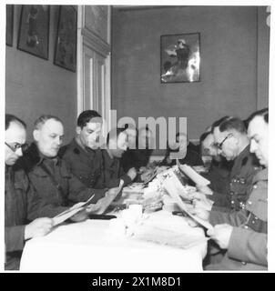 Les officiers supérieurs de la 1re brigade de fusiliers lisent des bulletins d'information dans la salle de messageries des officiers à Cupar, en Écosse, tout en équilibrant les tâches militaires avec les études universitaires. Banque D'Images