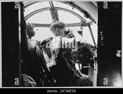 Un avion de la RAF Hudson survole Heligoland, le navigateur observant l'île de Sylt à l'aide de jumelles à fort grossissement lors d'un vol de reconnaissance. Banque D'Images