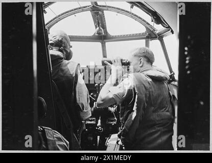 Un avion Hudson de la Royal Air Force survole Heligoland tandis que le navigateur observe l'île de Sylt à l'aide de jumelles à fort grossissement. Banque D'Images