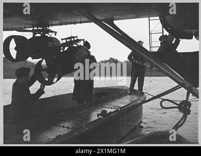 TROUVEZ L'ENNEMI, FRAPPEZ L'ENNEMI, PROTÉGEZ LA NAVIGATION. LA TRIPLE TÂCHE DU COMMANDEMENT CÔTIER. - (5797) fixation de charges de profondeur sur un hydravion, Royal Air Force Banque D'Images