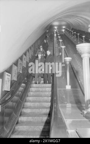 HARRY HARGREAVES SE REND AU PALAIS DE BUCKINGHAM : DU YORKSHIRE À LONDRES POUR RÉCUPÉRER SA MÉDAILLE DE L'EMPIRE BRITANNIQUE, 1943 - Harry Hargreaves descend un escalier roulant pour la première fois de sa vie, dans une station de métro, sur le chemin de son hôtel londonien. Selon la légende originale, Harry n'avait jamais vu d'escalator avant aujourd'hui, Banque D'Images