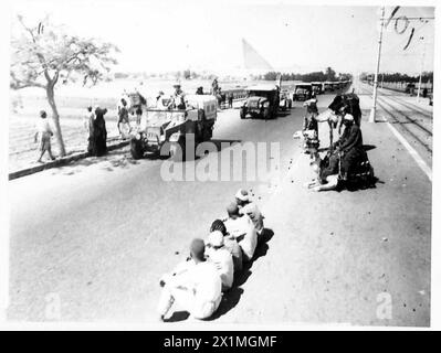 CANONS ET FOURNITURES TRAVERSENT LE DÉSERT - les indigènes et les cameliers s'arrêtent au bord de la route pour regarder une colonne d'artillerie de campagne se déplacer « à travers le désert », l'armée britannique Banque D'Images