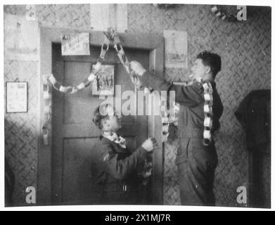 P.O.W. LA VIE EN ALLEMAGNE - les officiers britanniques des prisonniers de guerre ajoutent quelques décorations de Noël faites de vieux journaux et de craies de couleur à leur logement à Marisch Trubau, décembre 1943, Armée britannique, 21e Groupe d'armées Banque D'Images