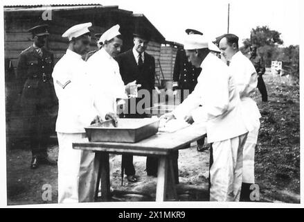 LE SECRÉTAIRE COLONIAL INSPECTE LES TROUPES CHYPRIOTES - le secrétaire colonial regarde les cuisiniers chypriotes préparer un repas, l'armée britannique Banque D'Images