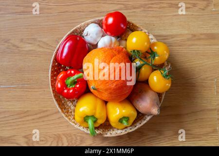 Panier, bol de fruits et légumes colorés sur une table en bois rustique Banque D'Images