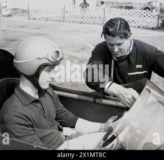 1962, historique, un jeune pilote masculin assis dans une voiture de course monoplace Cooper, obtenant les conseils d'un instructeur de l'école de conduite de Geoff Clarke à l'aérodrome de Finmere, Finmere, Bucks, Angleterre, Royaume-Uni. Banque D'Images