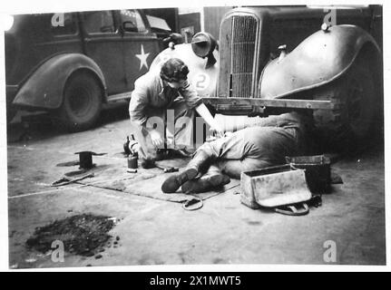 L/CPL. Alison de l'ATS assiste un collègue dans l'entretien des véhicules sous une voiture à Bruxelles, British Army, 21st Army Group. Banque D'Images