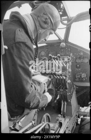 NAISSANCE D'Un BOMBARDIER : PRODUCTION D'AVIONS EN GRANDE-BRETAGNE, 1942 - le Flight Lieutenant pilote Talbot attache sur sa cuisse le coussin qui servira à enregistrer des informations sur ce bombardier Halifax lors de son premier vol d'essai à l'aérodrome de Radlett, Banque D'Images