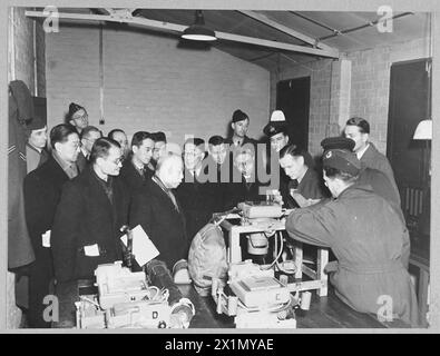 MISSION DE BONNE VOLONTÉ CHINOISE AVEC CHEFS DE COMMANDEMENT DES BOMBARDIERS - 12038 photo (publiée en 1944) spectacles - les membres de la mission de bonne volonté chinoise regardent une démonstration d'une caméra aérienne lorsqu'ils visitent un poste du commandement des bombardiers R.A.F. De gauche à droite - première rangée - Dr Wen Yuan-Ning Mr. Wang Yen-wu Mr. Hu Lin Mr. Han Lih-wu Dr Wang Shieh-chieh, Royal Air Force Banque D'Images