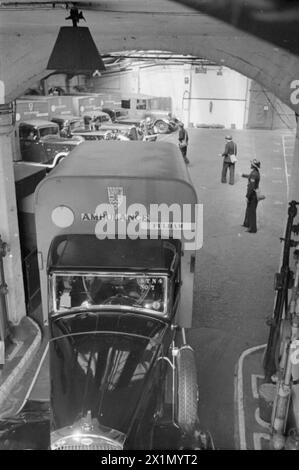 LA RECONSTRUCTION d'« UN INCIDENT » : FORMATION DE LA DÉFENSE CIVILE À FULHAM, LONDRES, 1942 - Une scène animée à l'intérieur de la station d'ambulance de Fulham alors que les travailleurs de la défense civile dirigent les ambulanciers hors du dépôt de Seagrave Road. Quatre ambulances sont envoyées à l'incident pour traiter les cas de civières, Banque D'Images