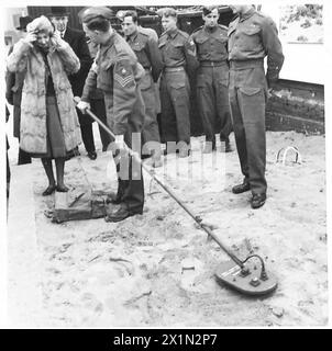 EXPOSITION DE L'ÉQUIPEMENT DE L'ARMÉE À BIRMINGHAM - sergent du génie royal expliquant comment utiliser le détecteur de mines polonais n ° 3 à la Maire de Birmingham. Elle règle les écouteurs avant de tester le détecteur. Des expositions de l'armée ont eu lieu dans tout le pays où peolpe a pu voir et essayer certains des équipements utilisés par les troupes britanniques. Ces photographies prises à Birmingham montrent les visiteurs à une exposition d'équipement de l'armée. Noir et blanc, armée britannique, ingénieurs royaux Banque D'Images