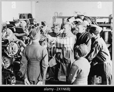 LES GARÇONS DE l'A.T.C. VISITENT L'UNITÉ DE FORMATION OPÉRATIONNELLE DE la R.A.F. - 13876 photo (publiée en 1944) montre - le sergent instructeur J.E. Gray de Swansea, Glam., décrivant les pièces d'un moteur aérodynamique démonté à une foule de cadets intéressés. Face à la caméra - de gauche à droite - Cadet G. Brown de Luton, Cadet R.R.N. Neale de Luton, et Cadet C.Glover de Luton, Royal Air Force Banque D'Images