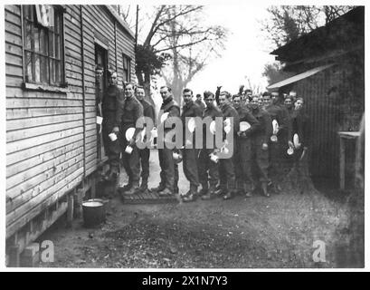 Les troupes de l'armée britannique s'alignent à la porte de la cuisine pour recevoir leurs rations de mi-journée pendant les opérations sur le terrain. Banque D'Images
