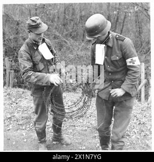 FIFTH ARMY : LANDING SOUTH OF ROME - German prisoners, with labels tied round their necks, at work removing barbed wire from the side of the railway track to Rome, British Army Stock Photo