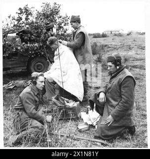 CINQUIÈME ARMÉE : DÉBARQUEMENT AU SUD DE ROME - Un barbier au travail sur la ligne de front. Pte. R. Sneath(l Loyals)couper les cheveux de l/CPL. W.Fox (1 fidèles). Attendant leur tour au premier plan à Pte. J.H. Jones (à gauche) et Pte. J. Platt, British Army Banque D'Images