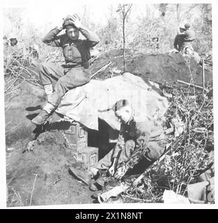 CINQUIÈME ARMÉE : ANZIO BRIDGEHEADINFANTRY PATROUILLE DANS LA TÊTE DE PONT (RECONSTRUITE DANS LA LIGNE) - tandis que le Sgt Trainor met ses bottes de patrouille, fus. Godber du 31 Strelley Street, Bulwell, Notts, met sa casquette de couette, British Army Banque D'Images