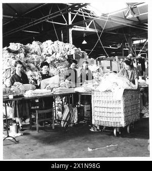 ROYAL ORDNANCE CORPS : DÉPÔT DE MAGASINS RETOURNÉS - soldats vêtements d'hiver sont nettoyés et réparés, puis reclassés pour la réédition, armée britannique Banque D'Images