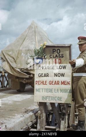 Un policier militaire dirige la circulation vers un pont flottant Bailey alors que les troupes de la 8e armée britannique traversent le fleuve po près de Ferrare, en Italie, le 28 avril 1945, dans l'armée britannique. Banque D'Images