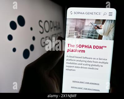 Personne tenant un téléphone portable avec la page web de la société suisse de logiciels de santé Sophia Genetics sa devant le logo. Concentrez-vous sur le centre de l'écran du téléphone. Banque D'Images