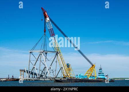 Dundalk (États-Unis d'Amérique). 16 avril 2024. Dundalk (États-Unis d'Amérique). 16 avril 2024. Les opérateurs de sauvetage du Commandement unifié utilisent la barge-grue Chesapeake 1000 pour déplacer une portion de 300 tonnes de fermes d'acier du pont Francis Scott Key qui bloque le chenal de Fort McHenry, le 16 avril 2024, près de Dundalk, Maryland. Le pont a été heurté par le porte-conteneurs de 984 pieds le 26 mars et s'est effondré tuant six travailleurs. Crédit : PO2 Ronald Hodges/US Coast Guard/Alamy Live News Banque D'Images