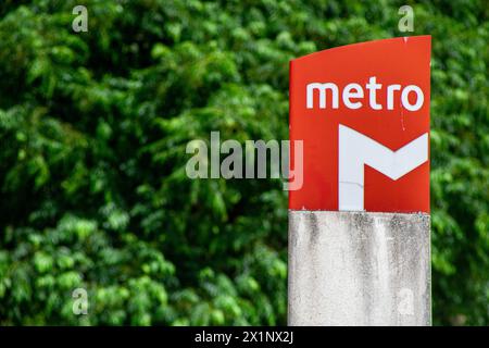 Symbole d'identification rouge du métro de Lisbonne sous fond d'arbres verts.Lisbonne-Portugal. Banque D'Images