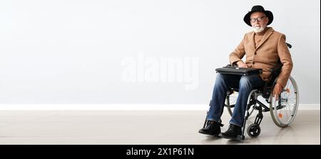 Homme senior en fauteuil roulant et avec valise près du mur lumineux. Bannière pour la conception Banque D'Images