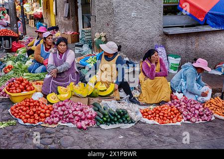 CUSCO, PÉROU - 30 SEPTEMBRE 2023 : un groupe de vendeuses de légumes avec leurs produits sont assis sur un trottoir à l'extérieur du marché de San Pedro dans le centre de Cusc Banque D'Images