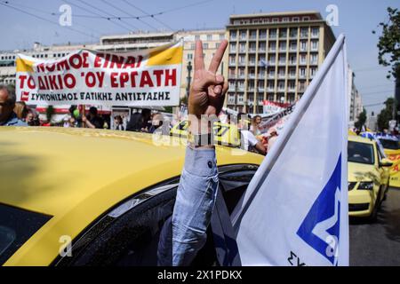 Athènes, Grèce. 17 avril 2024. Un chauffeur de taxi fait le signe de la victoire lors du rassemblement de protestation des chauffeurs de taxi. Des milliers de personnes sont descendues dans les rues de la capitale grecque lors d’une grève nationale de 24 heures condamnant la montée de la pauvreté et la flambée de l’inflation exigeant des augmentations de salaires et le rétablissement des conventions collectives de travail. Crédit : Dimitris Aspiotis/Alamy Live News Banque D'Images