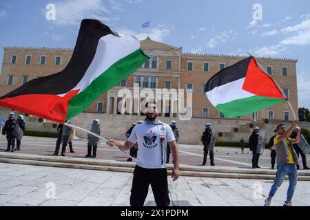 Athènes, Grèce. 17 avril 2024. Les manifestants brandissent le drapeau palestinien devant le parlement grec en criant « Palestine libre ». Des milliers de personnes sont descendues dans les rues de la capitale grecque lors d’une grève nationale de 24 heures condamnant la montée de la pauvreté et la flambée de l’inflation exigeant des augmentations de salaires et la restauration des conventions collectives de travail. Crédit : Dimitris Aspiotis/Alamy Live News Banque D'Images