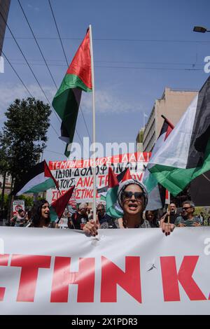 Athènes, Grèce. 17 avril 2024. Une manifestante tenant un drapeau palestinien crie des slogans exprimant sa solidarité avec la Palestine. Des milliers de personnes sont descendues dans les rues de la capitale grecque lors d’une grève nationale de 24 heures condamnant la montée de la pauvreté et la flambée de l’inflation exigeant des augmentations de salaires et le rétablissement des conventions collectives de travail. Crédit : Dimitris Aspiotis/Alamy Live News Banque D'Images