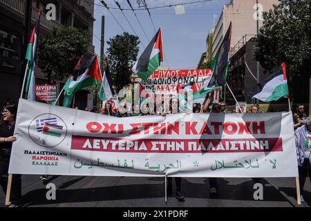 Athènes, Grèce. 17 avril 2024. Les manifestants défilent avec un drapeau palestinien et une banderole avec des slogans exprimant leur solidarité avec la Palestine. Des milliers de personnes sont descendues dans les rues de la capitale grecque lors d’une grève nationale de 24 heures condamnant la montée de la pauvreté et la flambée de l’inflation exigeant des augmentations de salaires et le rétablissement des conventions collectives de travail. Crédit : Dimitris Aspiotis/Alamy Live News Banque D'Images