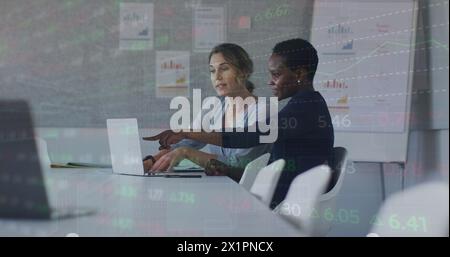 Des collègues caucasiens et afro-américains regardent un ordinateur portable Banque D'Images