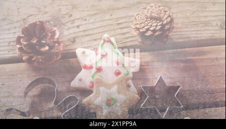 Un biscuit en forme d'étoile avec glaçage vert et rouge se trouve entre les pommes de pin Banque D'Images