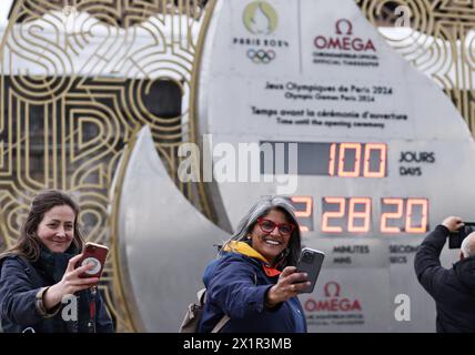 Paris, France. 17 avril 2024. Les touristes prennent des selfies avec un compte à rebours pour les Jeux Olympiques de Paris 2024 devant la Tour Eiffel à Paris, France, le 17 avril 2024. Crédit : Gao Jing/Xinhua/Alamy Live News Banque D'Images