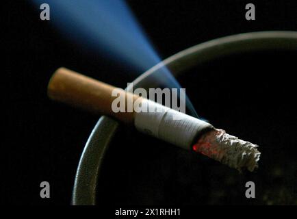 Dossier photo datée du 14/06/2007 d'une cigarette brûlant sur un cendrier. Une étude suggère une augmentation de la proportion de femmes des classes moyenne et supérieure de moins de 45 ans qui fument. Alors que les taux de tabagisme ont baissé chez les femmes de la classe ouvrière en Angleterre, ils semblent avoir bondi dans les groupes les plus favorisés. De plus, le vapotage chez toutes les femmes âgées de 18 à 45 ans a plus que triplé en une décennie, passant de 5,1 % à 19,7 % entre 2013 et 2023, ont constaté les chercheurs. Date d'émission : jeudi 18 avril 2024. Banque D'Images