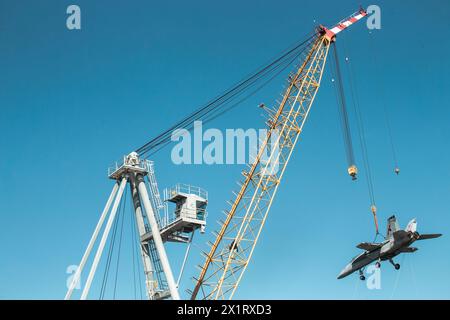 NORFOLK, Virginie (15 avril 2024) Une grue exploitée par Naval Facilities Engineering Systems Command soulève un avion d'entraînement utilisé pour des dommages aéronautiques Banque D'Images