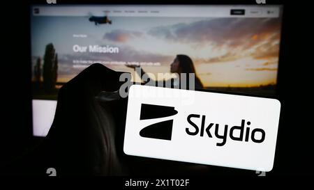 Personne tenant le téléphone portable avec le logo de la société américaine de fabrication de drones Skydio Inc. devant la page Web de l'entreprise. Concentrez-vous sur l'affichage du téléphone. Banque D'Images