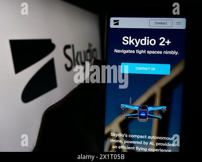 Personne tenant le téléphone portable avec la page Web de la société américaine de fabrication de drones Skydio Inc devant le logo de l'entreprise. Concentrez-vous sur le centre de l'écran du téléphone. Banque D'Images