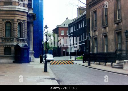 Vue générale de Downing Street en avril 1987 avec faible sécurité et Austin Montego ou Austin Maestro voitures de la période des années 1980. Maçonnerie sale non nettoyée du Cabinet Office et du Foreign Office Banque D'Images