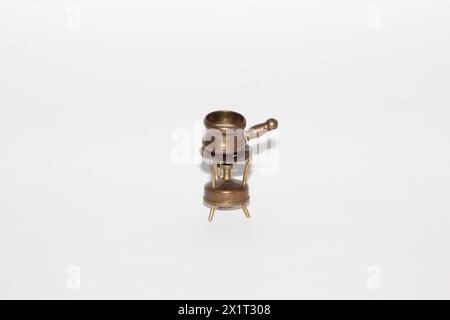 Un pot de fondue en cuivre miniature Vintage sur un mini brûleur Banque D'Images
