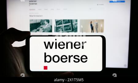 Personne tenant le téléphone portable avec le logo de la société de bourse autrichienne Wiener Börse AG en face de la page Web de l'entreprise. Concentrez-vous sur l'affichage du téléphone. Banque D'Images