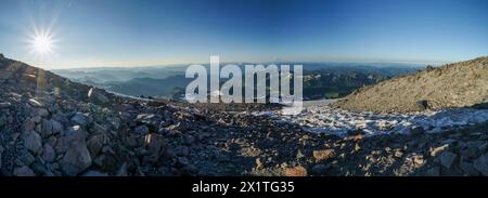 Pacific Crest Trail. Une vue panoramique sur une chaîne de montagnes avec un soleil qui brille sur les rochers. Le ciel est bleu et le soleil est brillant Banque D'Images