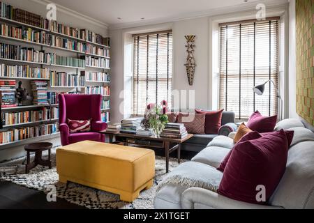 Couleurs contrastées et étagères à livres avec l'intimité des stores vénitiens dans la maison Chelsea, Londres, Royaume-Uni Banque D'Images