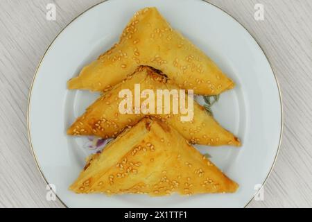 Cuisine orientale. Samosas dans une plaque sur fond blanc. Cuisine maison. Restauration rapide. Vue de dessus. Banque D'Images