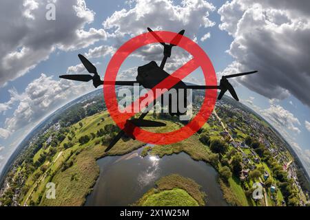 Aucun concept de zone de drones ne signe pour interdire l'utilisation de drones dans l'espace aérien. silhouette de drone dans un cercle rouge avec une bande barrée sur un fond de planète minuscule Banque D'Images