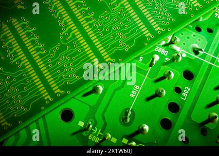 Gros plan de cartes de circuits imprimés électroniques éclairées en vert fluorescent avec points et lignes de soudure en argent, Studio composition, Québec, Canada Banque D'Images