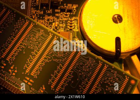 Gros plan de cartes de circuits imprimés électroniques éclairées orange et jaune avec disque dur, Studio composition, Québec, Canada Banque D'Images