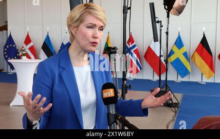 Rostock, Allemagne. 18 avril 2024. Manuela Schwesig (SPD), ministre-présidente de Mecklembourg-Poméranie occidentale, s’entretient avec les journalistes après la conférence de presse de la Journée internationale des affaires de la mer Baltique, avec les drapeaux des pays participants en arrière-plan. Les participants de neuf pays de la mer Baltique échangent des idées sur les entreprises neutres pour le climat sous le slogan «devenir partie du réseau». Crédit : Bernd Wüstneck/dpa/Alamy Live News Banque D'Images