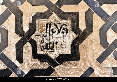 Sculptures artistiques en pierre, Alhambra, Grenade, Une mosaïque avec calligraphie islamique en noir et blanc sur un carrelage, Grenade, Andalousie, Espagne Banque D'Images