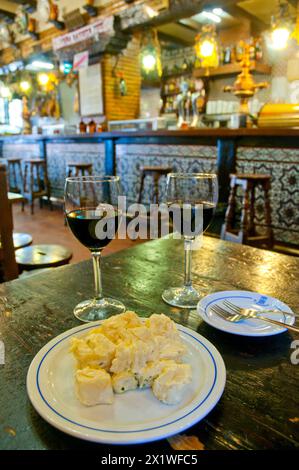 Pommes de terre alioli avec deux verres de vin rouge dans un bar. Madrid, Espagne. Banque D'Images